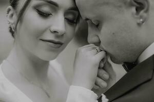 el novio Besos el de la novia mano, negro y blanco foto, elegante novias delicado constituir. Boda anillo foto