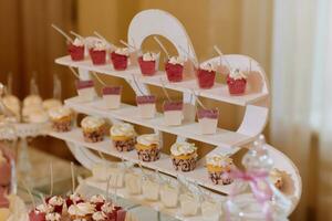 un delicioso boda. caramelo bar para un banquete. celebracion concepto. de moda postres mesa con dulces, dulces. frutas foto