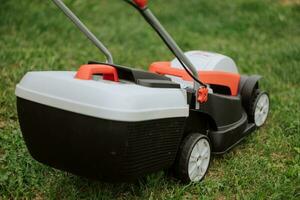 Lawn mover on green grass in modern garden. Machine for cutting lawns. Safety equipment with garden tools photo
