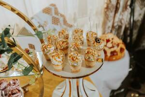 un delicioso boda. caramelo bar para un banquete. celebracion concepto. de moda postres mesa con dulces, dulces. frutas foto