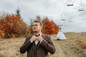 Young man on the hill of a mountain. Businessman. Bridegroom. Groom. Aerial photo