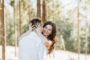 Young happy couple in love hugging smiling and having fun in the mountains. High quality photo. A girl in a beautiful white dress photo