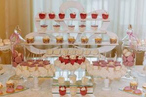 un delicioso boda. caramelo bar para un banquete. celebracion concepto. de moda postres mesa con dulces, dulces. frutas foto