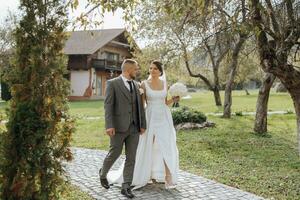 elegante joven novias, contento en su día, disfrutar cada otro. ellos son caminando en el primavera parque. primavera boda. natural maquillaje foto