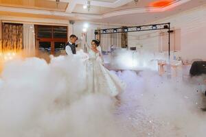 the first dance at the wedding of the bride and groom in an elegant restaurant with great lighting and atmosphere. Heavy smoke photo