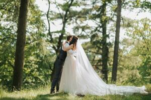 Stylish young brides, happy on their day, enjoy each other. The bride hugs the groom. Portrait. Spring wedding. Natural makeup photo