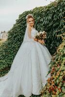 bride in the garden among greenery. Royal wedding concept. Chic bride's dress with a long train. Tenderness and calmness. Portrait photography photo