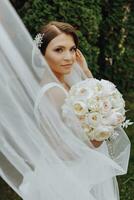 Wedding bouquet of beautiful white wedding flowers in the hands of the bride. outdoor photo in the park. Stylish bride. Delicate make-up