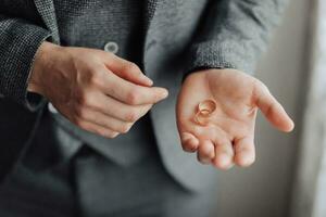 foto de Boda anillos ese mentira hermosamente en el del novio manos. un hermosa foto con detalles de el boda. Boda día. luz. un elegante hombre. hermosa manos