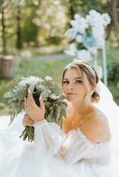 Bride's bouquet. Portrait of a beautiful bride with a wedding bouquet. Brown-haired bride with curly hair and gentle makeup photo