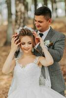 bride and groom on the background of a fairy-tale forest. Royal wedding concept. The groom puts on the bride's tiara. Tenderness and calmness. Portrait photography photo