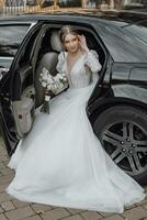 maravilloso novia con de moda maquillaje y peinado en lujo Boda vestir en negro Boda coche sentado en espalda asiento y posando para fotógrafo foto