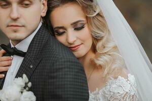 portrait of a young couple of the bride and groom on their wedding day. the bride hugs the groom from behind. stylish portrait close-up photo