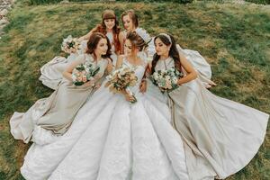 Photo of the bride and bridesmaidswith wedding bouquets. Wedding day. Happy girls at their best friend's wedding. Beautiful bride with her friends. Summer wedding