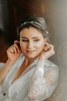 beautiful bride on a retro sofa in a dressing gown with open legs, photo portrait. Wedding hairstyle, light makeup