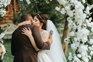 Beautiful wedding couple on the wedding autumn ceremony. the round arch is decorated with white flowers photo