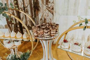 un delicioso boda. caramelo bar para un banquete. celebracion concepto. de moda postres mesa con dulces, dulces. frutas foto