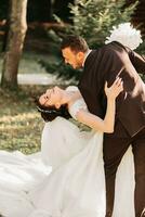 Amazing smiling wedding couple. Pretty bride and stylish groom. Romantic wedding moment, newlyweds in nature in the park. photo