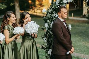 Beautiful wedding couple on the wedding autumn ceremony. the round arch is decorated with white flowers photo