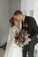 bride clings to the jacket of the groom's boutonniere of fresh flowers photo