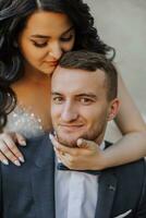 Happy young couple, bride with long curly hair in white dress near the castle. Beautiful girl in the park. Handsome groom. Close-up portrait photo