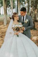 bride and groom on the background of a fairy-tale forest. Royal wedding concept. the groom embraces the bride. Tenderness and calmness. Portrait photo