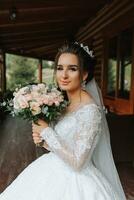 The bride is holding a beautiful wedding bouquet of white and pink roses. portrait of the bride photo