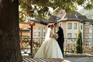 Wedding Portrait. Wedding ceremony painting in nature. The groom holds a bouquet and looks at the bride, the bride puts on the groom's wedding ring. Beautiful golden arch and fresh flowers photo