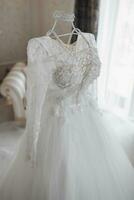 elegant wedding dress with a long train on a mannequin is located in a hotel room with a royal interior photo