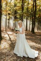 the bride is walking against the background of a fairy-tale fog in the forest. The rays of the sun break through the smoke, a fairy-tale wedding photo