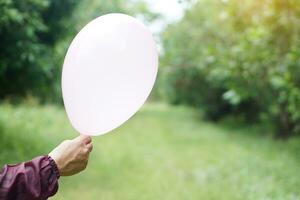 cerca arriba manos sostener globo en el parque. concepto, preparar globo para jugando juegos como un juguete, Decorar fiesta o celebracion. recreación o ocio actividad. divertido y contento tiempo. foto