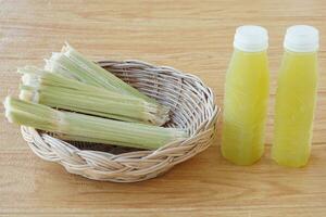 Closeup bottles of fresh sugar cane juice, put on basket. Concept, healthy natural beverage made from agriculture crop. Homemade drinks, has medicinal and herbal properties photo