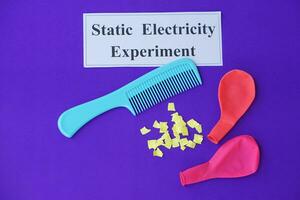 Comb, ballons and small pieces of paper. Equipment, prepared to do experiment about static electricity. Blue background. Concept, Science lesson, fun and easy experiment. Education. Teaching aids. photo