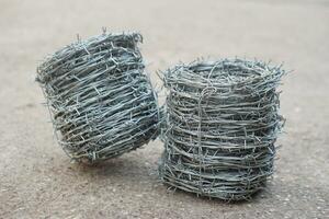Two rolls of metal barbed wire. Concept, construction tool. Barbed wire is used for make fences , secure property ,make border to show the territory of area. photo