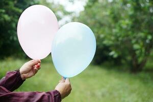 cerca arriba manos sostener globos en el parque. concepto, preparar globo para jugando juegos como un juguete, Decorar fiesta o celebracion. recreación o ocio actividad. divertido y contento tiempo. foto