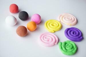Colorful plasticine were sculpted into different shapes, balls and rolls. Concept, materials or tool for practicing imagination and brain development for kids. photo