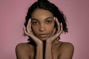 Studio shot with black woman on pink background.Skincare,wellness,wellbeing and beauty concept. photo