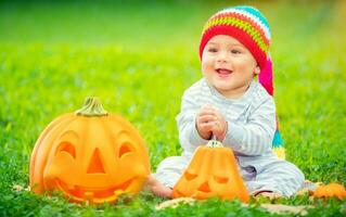 linda bebé con Víspera de Todos los Santos calabazas foto