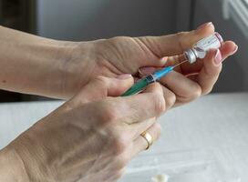 Close upshot of the woman preparing medicine for injection. Healthcare photo