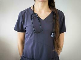 Shot of the female doctor in uniform against the white wall. Healthcare photo