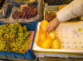 un variedad de Fresco frutas y vegetales en monitor a el mercado. mujer cosecha mangos. comida foto