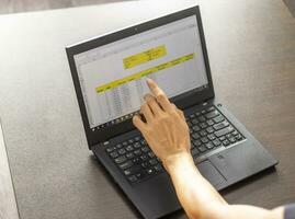 Shot of a woman working on the laptop showing an excel sheet on the screen with bank loan amortization table. Accounting photo