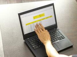 Shot of a woman working on the laptop showing an excel sheet on the screen with bank loan amortization table. Accounting photo