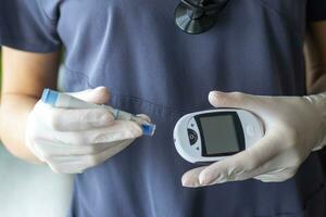 Close up shot of the nurse holding glucometer instrument. Healthcare photo