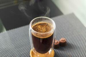 Shot of the hot water poured into the transparent cup to brew the coffee. Beverage photo