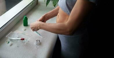 Close upshot of the woman preparing medicine for injection. Healthcare photo