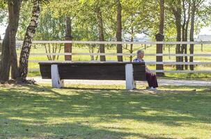 Baranovichi, Belarus - 10.03.2023 - Shot of an senior lady enjoying day out in the park. Concept photo