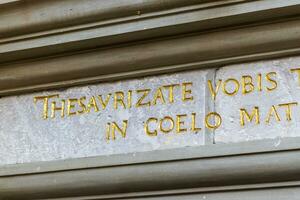 Close up shot of writings on latin language on the facade of the old building photo