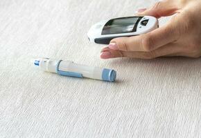 Close up shot of the glucometer instrument on the white surface. Healthcare photo