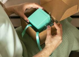 Close up shot of the woman holding unwrapped gift box. Holiday photo